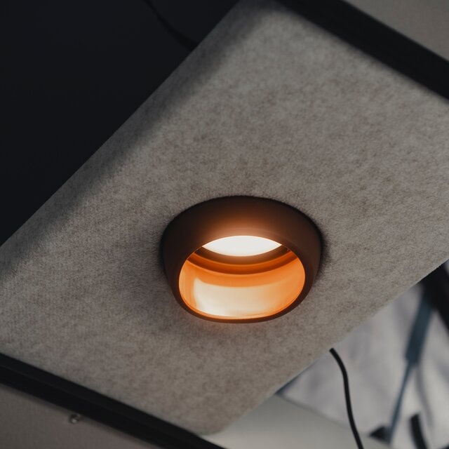 Braune Pendelleuchte hängt in einer grauen Halterung an der Decke in einem Camper Van