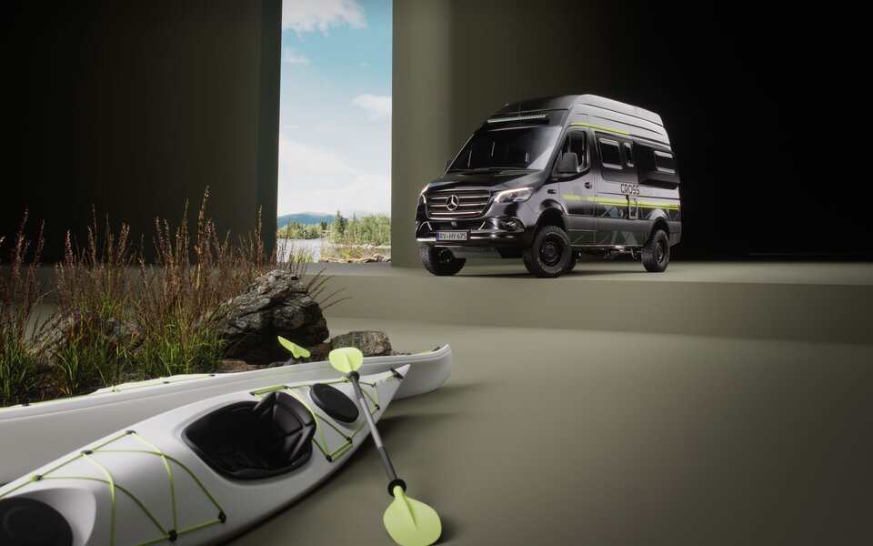 Campervan Mercedes nero con decalcomanie sportive e accenti verdi in una stanza dove una finestra dal pavimento al soffitto mostra un paesaggio lacustre boscoso. In primo piano, due kayak bianchi con pagaie verdi accanto a pietre grosse e erbe fini.	