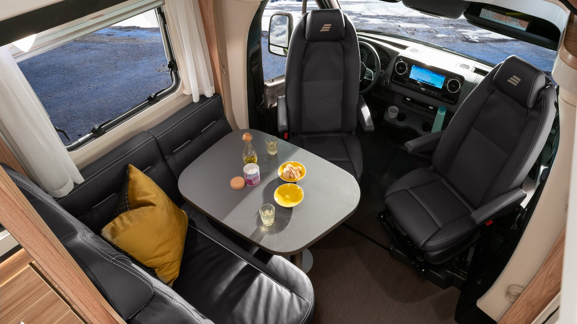 Seating group with driver's seats in the HYMER ML-T 570 CrossOver with yellow cushions, dark leather, set table
