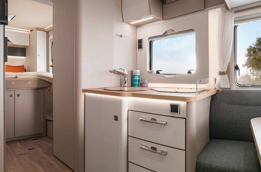 Garderobe, keukenblok en slaapkamer in de HYMER T-Klasse S-camper