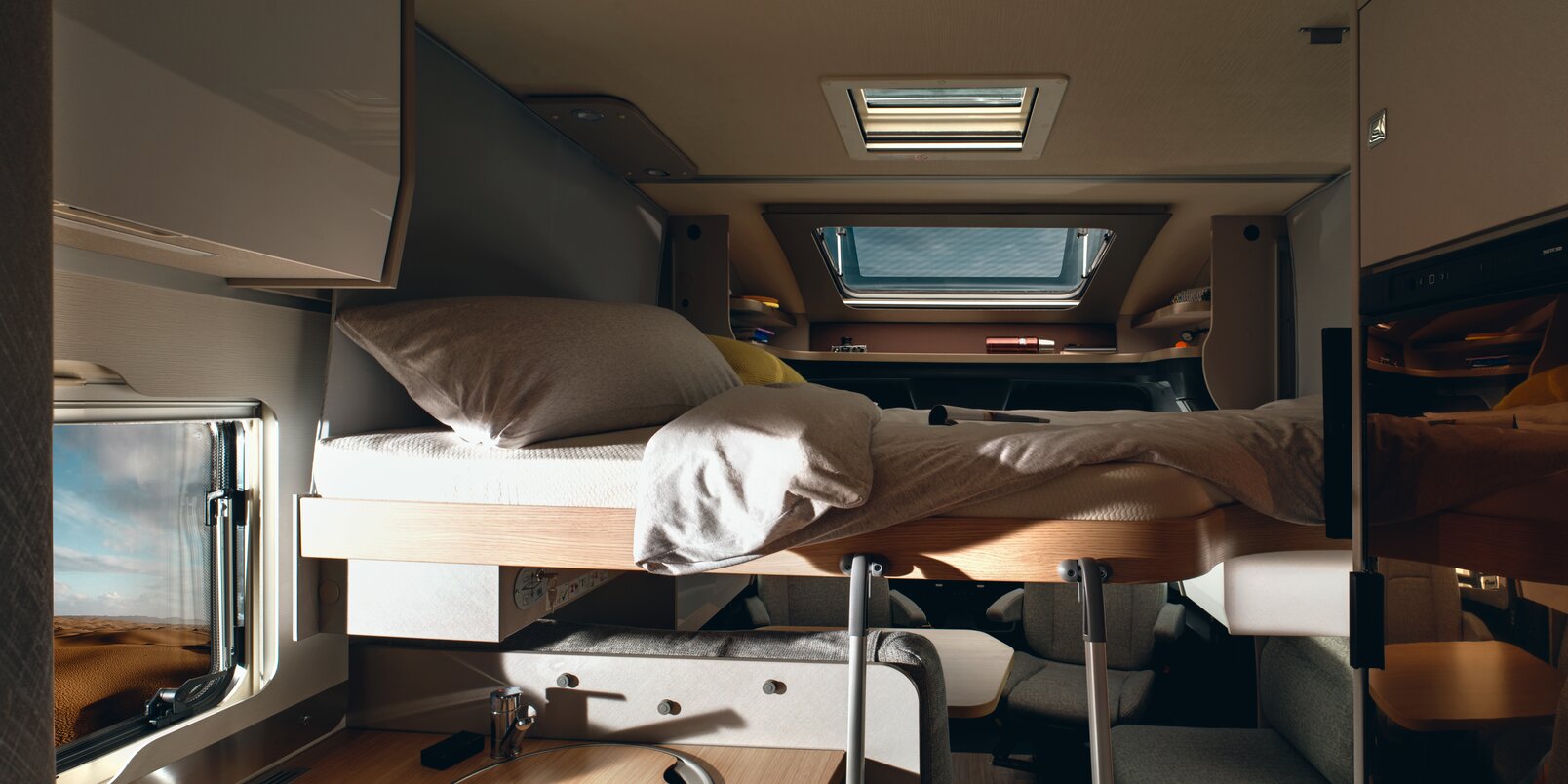 Covered fold-down bed above the seating area, ladder, kitchen block, panoramic skylight on the HYMER T-Class S