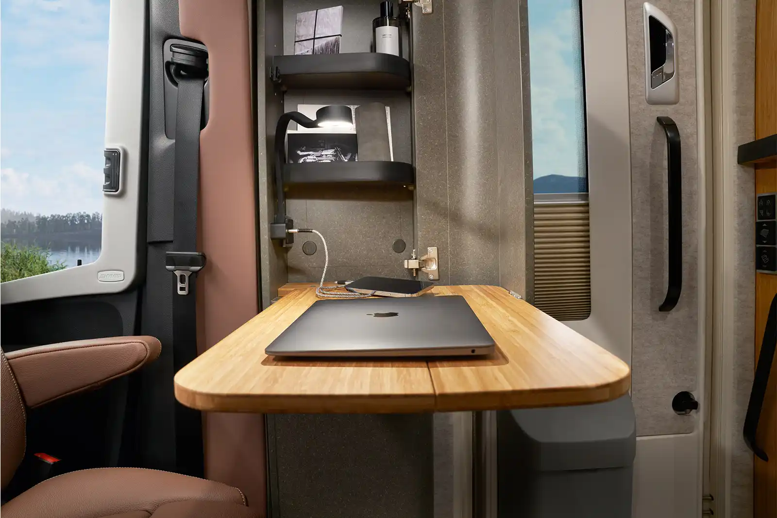 On the table in the Mobile Office Space of the HYMER Venture S lies a laptop.