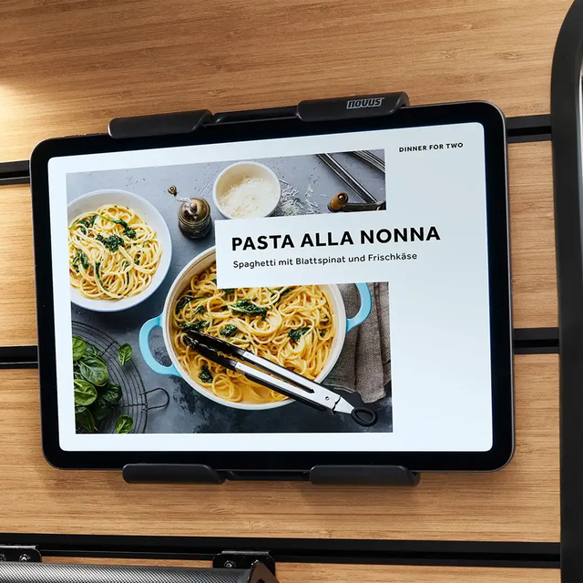 A tablet holder with a tablet PC is mounted on the multifunction wall in the Magic Diner of the HYMER Venture S.