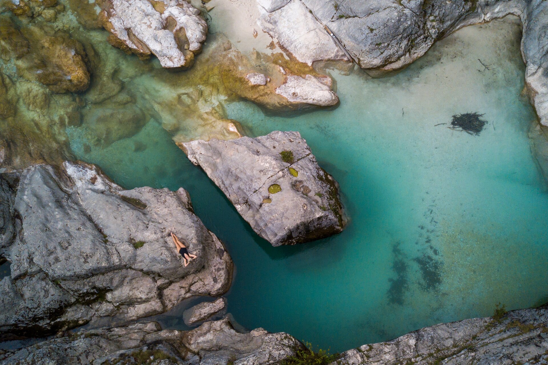 Flod med turkost vatten / Soča-dalen ovanifrån / kvinna ligger på klippor för att sola