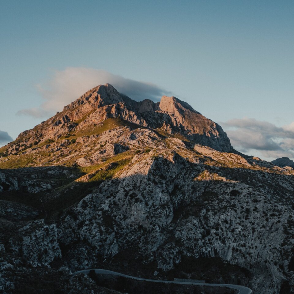 Utsikt fra forsiden av Venture S, med taket utfoldet, med fjell og vann i bakgrunnen.