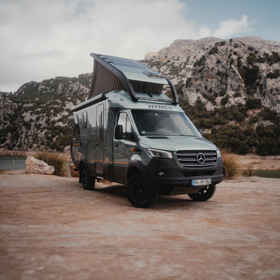 Utsikt fra baksiden av Venture S, med taket og Sunset Deck utfoldet, med fjell og vann i bakgrunnen.