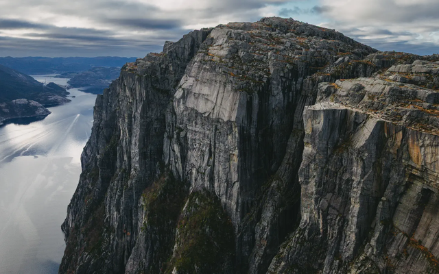Blick auf einen großen Berg mit Aussichtsplattform, im Hintergrund links ist der Fjord