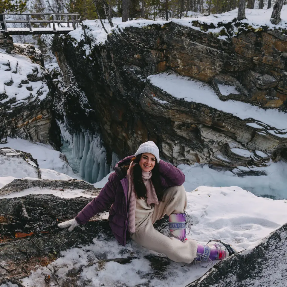 View of a woman in a snowy landscape, a gorge in the background