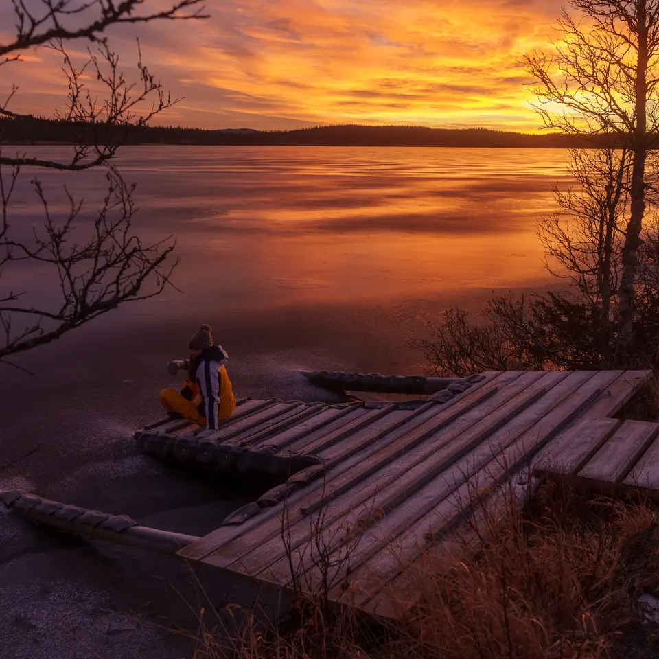 Blick auf einen Steg am See, im Hintergrund ist ein schöner Sonnenuntergang