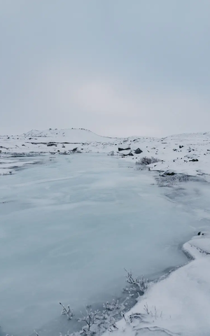 Vereister See in winterlicher Schneelandschaft