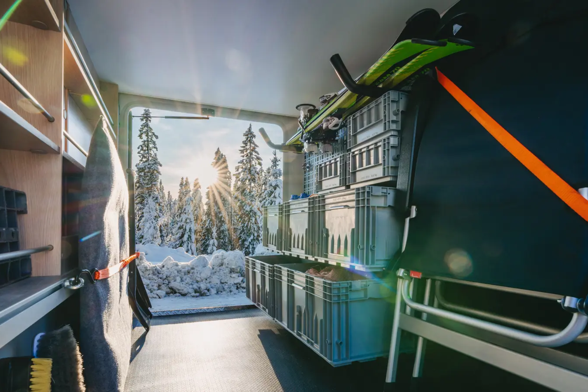 Blick durch die Heckgarage des HYMER B-MC T BlackLine, in der Heckgarage sind verschiedene Sachen verstaut, im Hintergrund ist ein Wald bedeckt mit Schnee