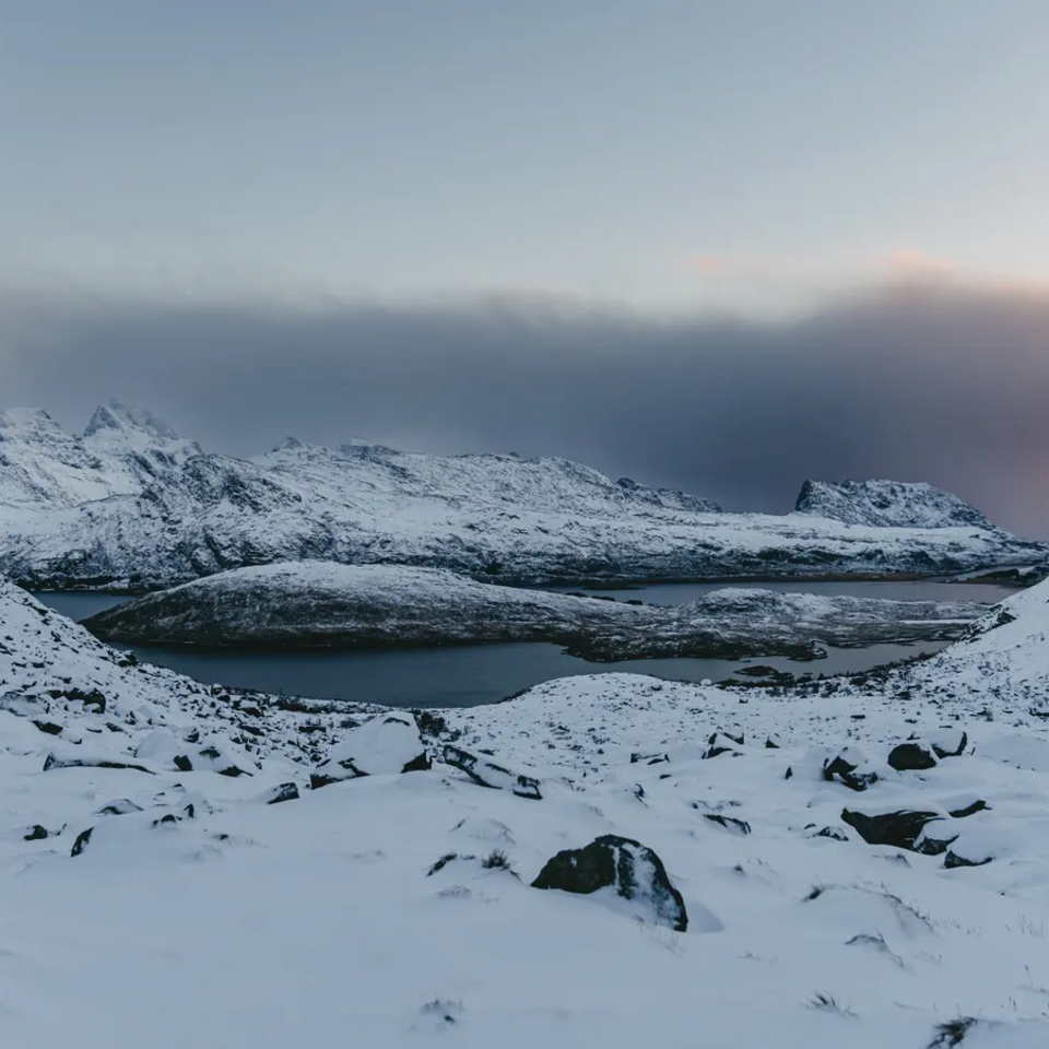 Verschneite Berge, im Hintergrund ist der Fjord