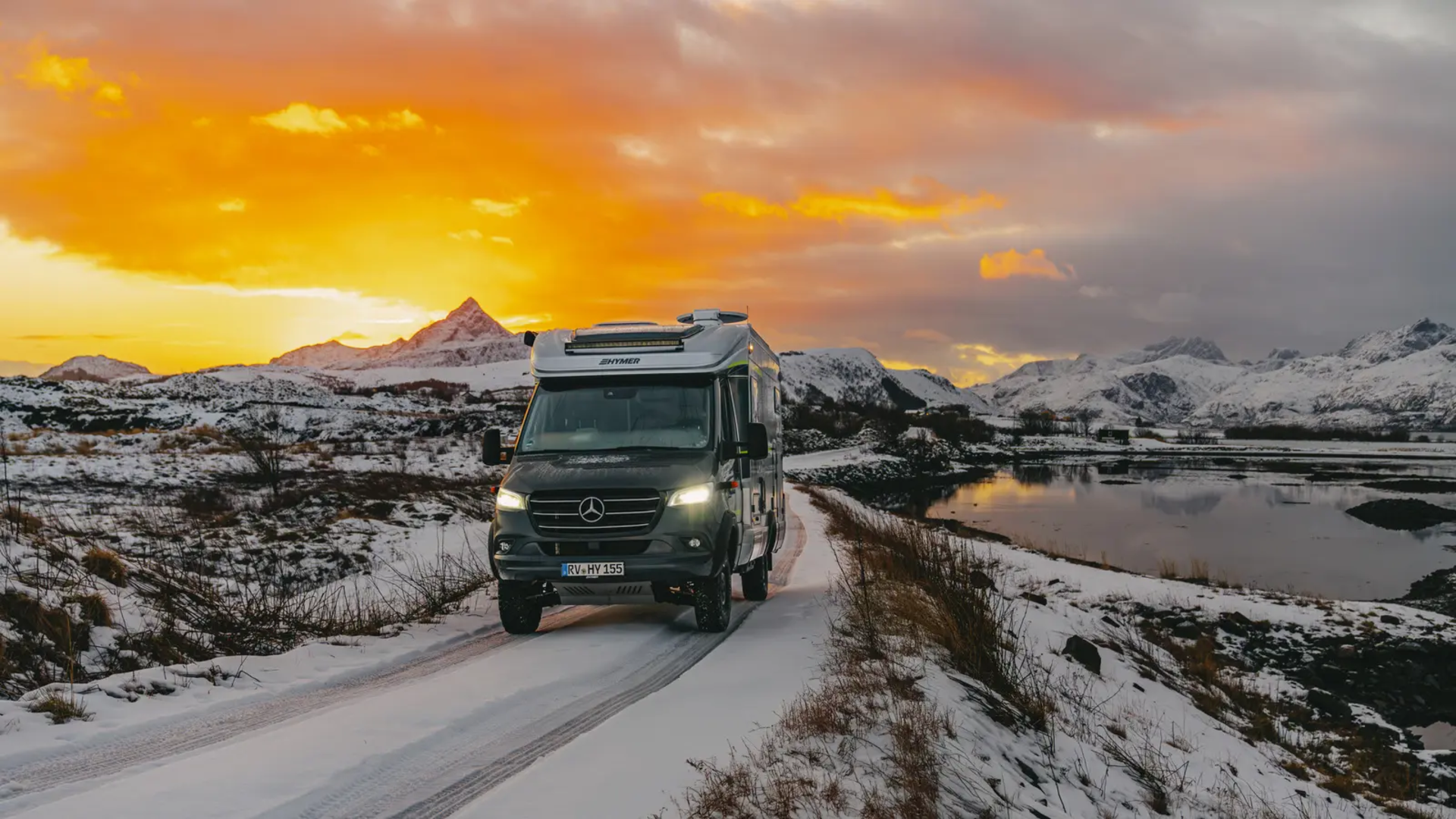HYMER ML-T 570 fährt auf der Straße, im Hintergrund sind Schneeberge und ein schöner Sonnenuntergang