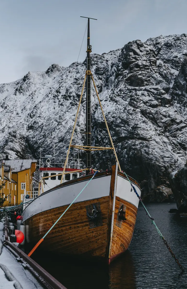 Boot liegt an, im Hintergrund ist ein Großer Berg mit Schnee