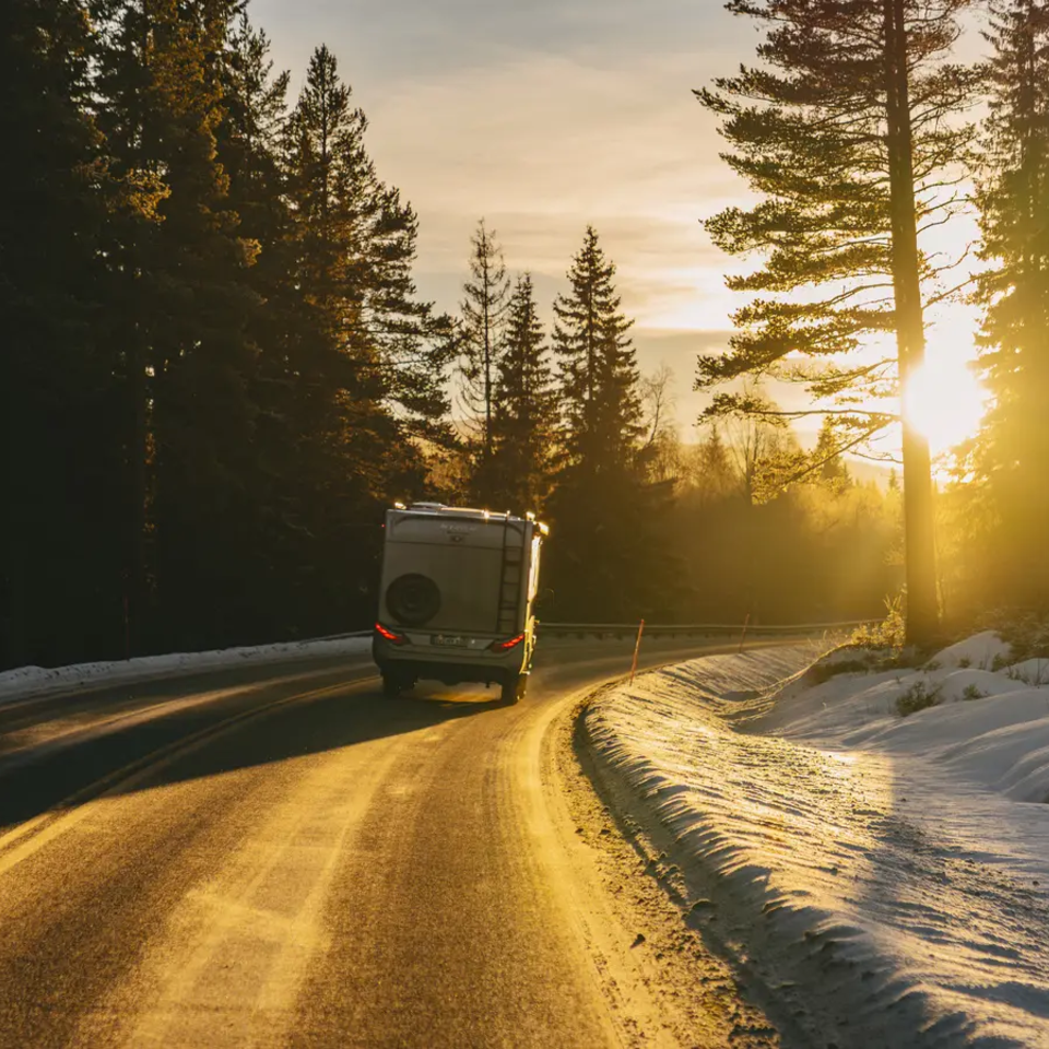 HYMER ML-T 570 CrossOver fährt in einem Wald Richtung Sonnenuntergang