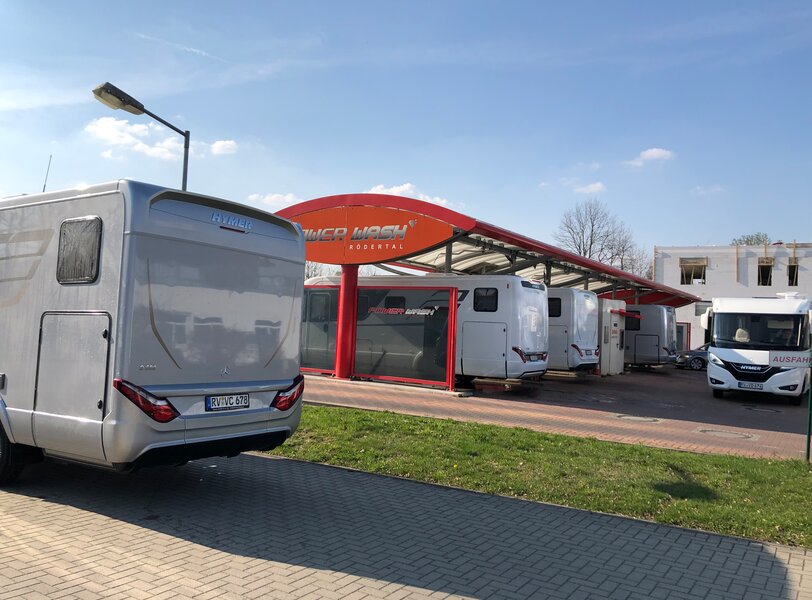 Hymer motorhome in front of a carwash that is filled with other motorhomes
