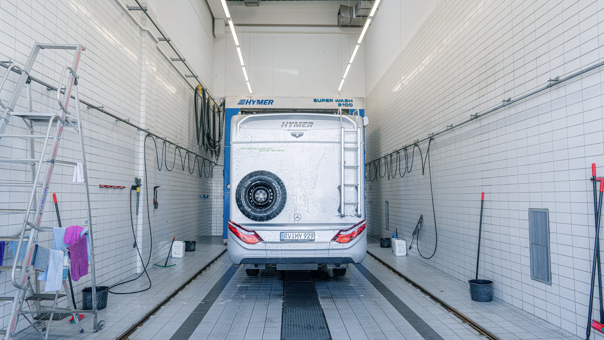 Heck-Ansicht des in der Waschhalle stehenden Hymermobils mit Reserverad