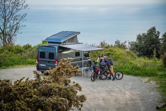 Campingsituation mit ausgefahrener Markise und Bikern vor dem Camper Van HYMER Yosemite auf Fiat Chassis 
